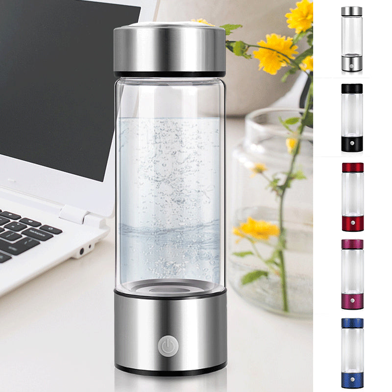 Hydrogen water generator bottle shown next to a laptop and flowers, featuring high borosilicate glass design.
