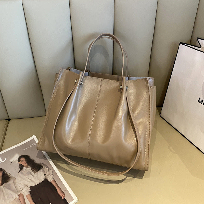 High-end leather tote bag displayed on a table, showcasing its sleek design and premium quality.