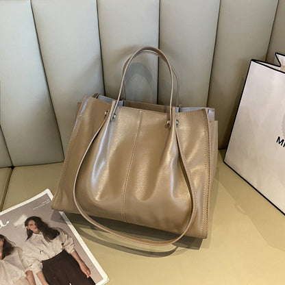 High-end leather tote bag displayed on a table, showcasing its sleek design and premium quality.