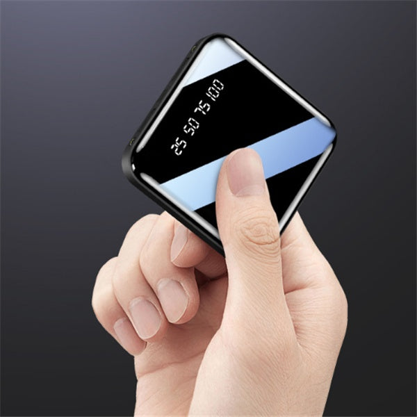 Portable mirror power bank 20000 mAh held in hand with digital display showing battery status.