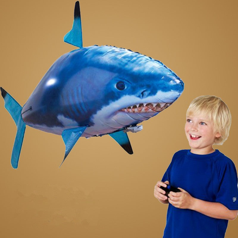 Boy enjoying the Remote Control Shark Toy as it swims in the air, showcasing its vibrant colors and fun design.