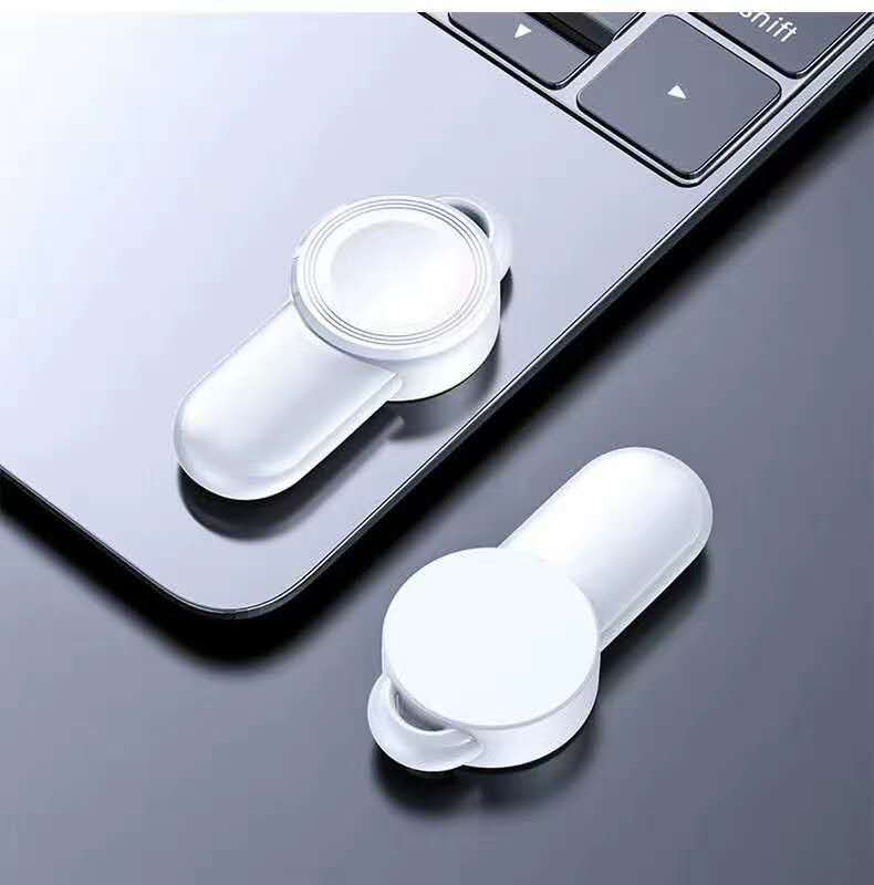 portable wireless charger for watch on a laptop surface, showcasing sleek design and wireless charging capability.
