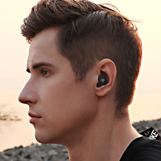 KZ S1 true wireless bluetooth headphones being worn by a young man outdoors near a body of water.