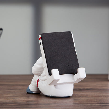 Cute astronaut phone stand showcasing a stylish astronaut shape, perfect for holding mobile devices on a desk.