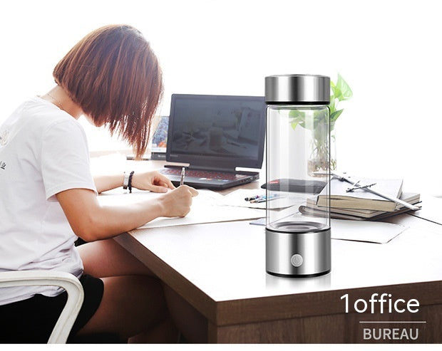Hydrogen water generator bottle on a desk beside a woman working at her office.