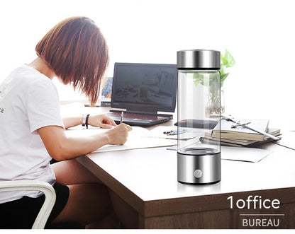 Hydrogen water generator bottle on a desk beside a woman working at her office.
