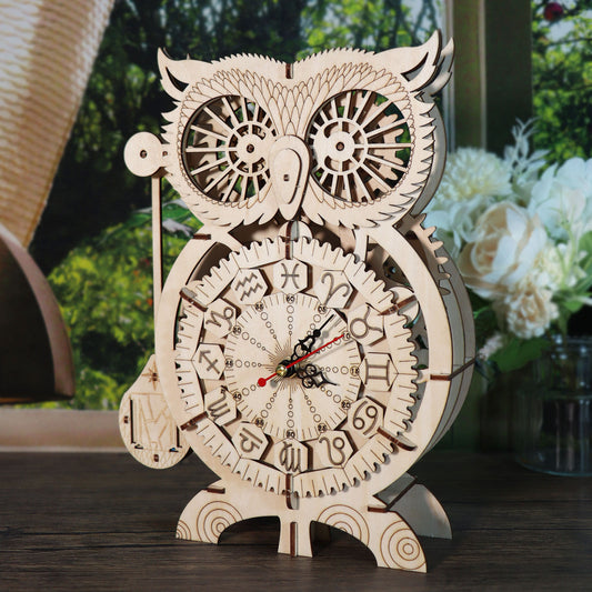 Wooden owl clock puzzle kit displayed on a wooden table with flowers in the background.