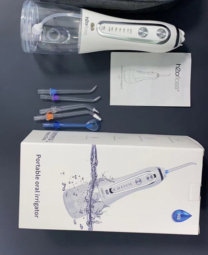 H2ofloss portable water flosser with accessories and packaging displayed on a flat surface.