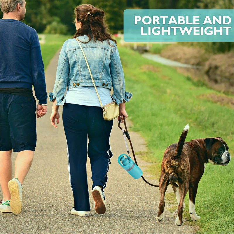 Couple walking a dog with portable dog pooper scooper with bag dispenser in hand, showcasing its lightweight design.