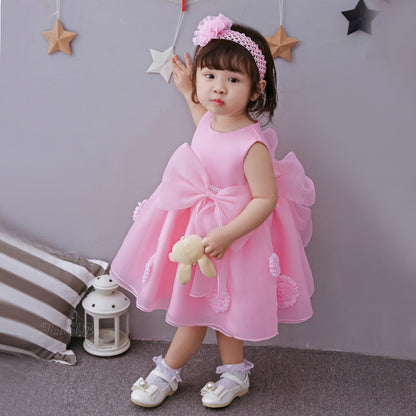Cute girl wearing a pink princess dress for girls with a big bow, holding a plush toy, perfect for spring and summer.