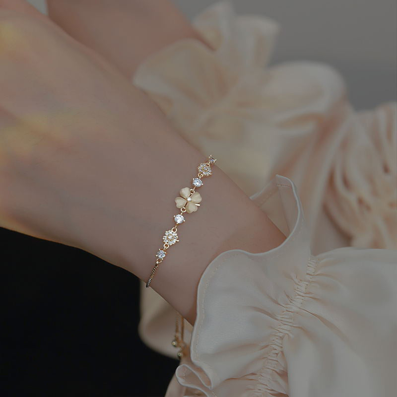 Versatile Japanese and Korean minimalist cat eye stone bracelet worn on a hand with a stylish blouse.