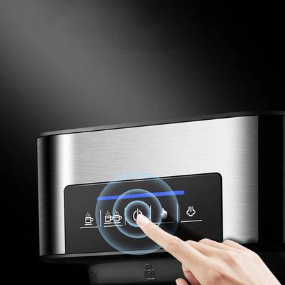 A hand using the touch button on a home espresso machine with milk frother for brewing coffee.