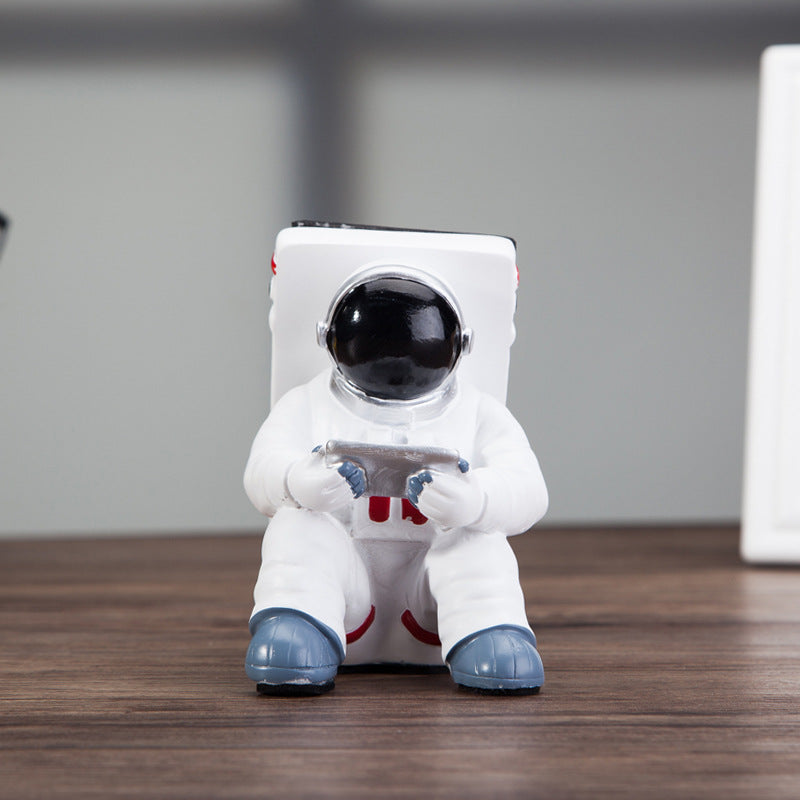 Cute astronaut phone stand designed as a spaceman, perfect for holding mobile phones on your desk.