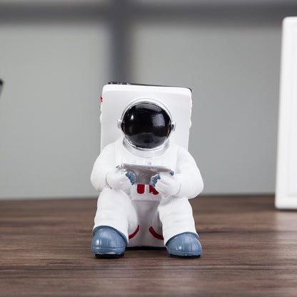 Cute astronaut phone stand designed as a spaceman, perfect for holding mobile phones on your desk.