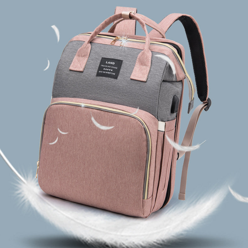 large capacity mummy baby backpack in pink and gray with multiple pockets and stylish design.