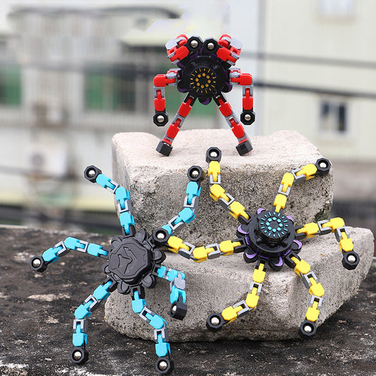 Deformed fidget spinner toys for children in vibrant colors, displayed on a stone surface.