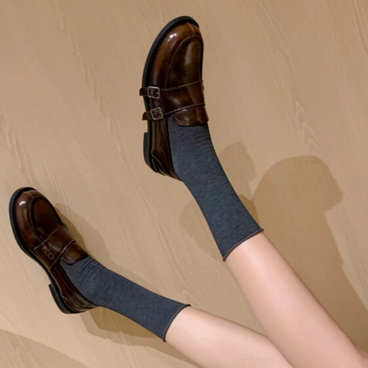 Retro distressed brown leather shoes paired with gray socks, showcasing a trendy casual look.