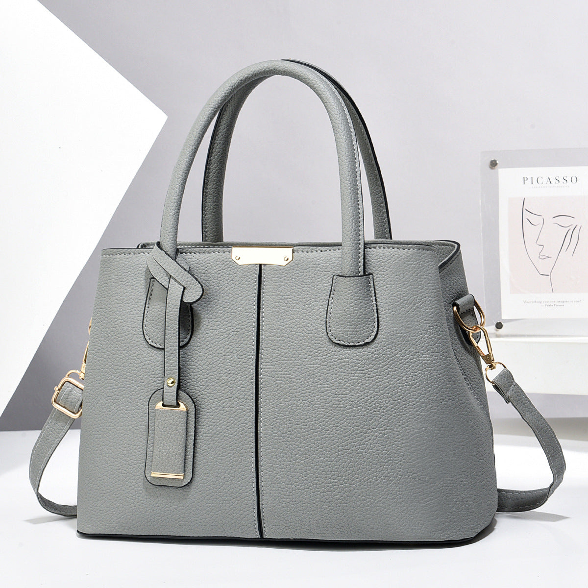Women's large capacity tote bag in elegant grey synthetic leather, perfect for casual daily use, featuring adjustable strap and stylish design.