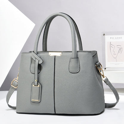 Women's large capacity tote bag in elegant grey synthetic leather, perfect for casual daily use, featuring adjustable strap and stylish design.