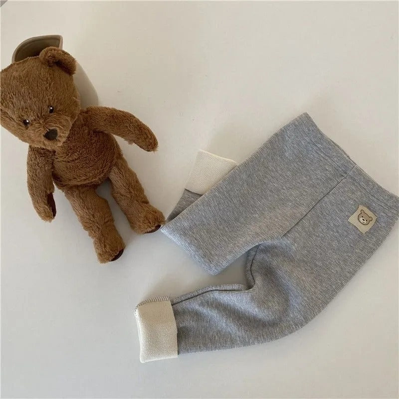 fleece-lined girls leggings in gray color next to a brown teddy bear on a white surface