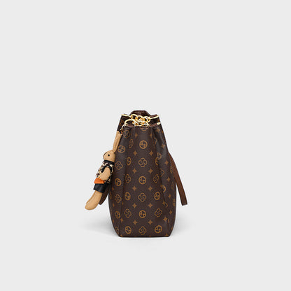 large-capacity women's commuter bag in brown synthetic leather with chic design and attached doll accessory.