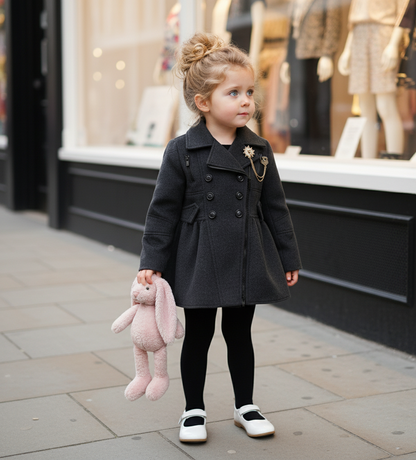 Little girl wearing a vintage wool-blend coat for toddlers, holding a pink bunny plush toy outside a store.
