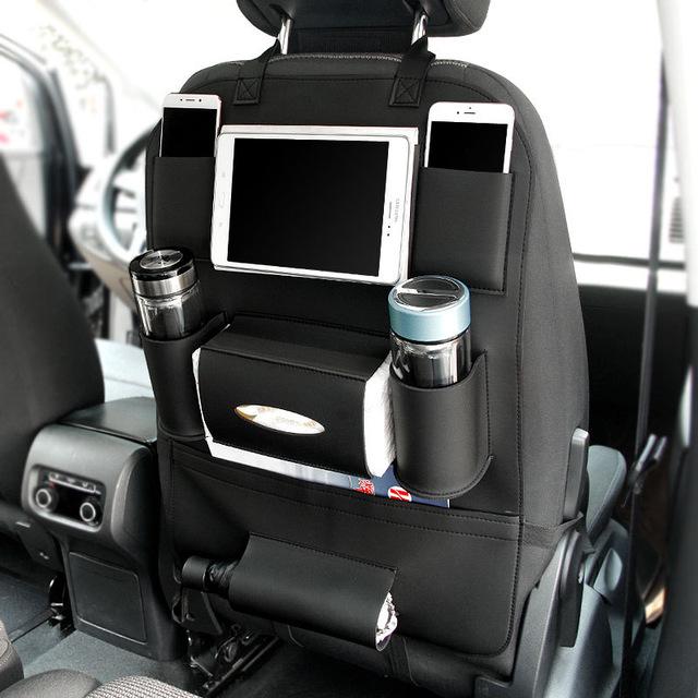 Leather car seat organizer with multiple pockets for tablets, drinks, and personal items in a vehicle.