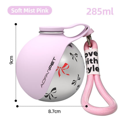 Portable dog water bottle in soft mist pink with a convenient carrying strap, ideal for pet hydration on the go.