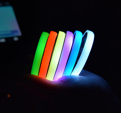 Colorful LED light-up car coaster demonstrating various colors in hand, showcasing solar and USB charging features.
