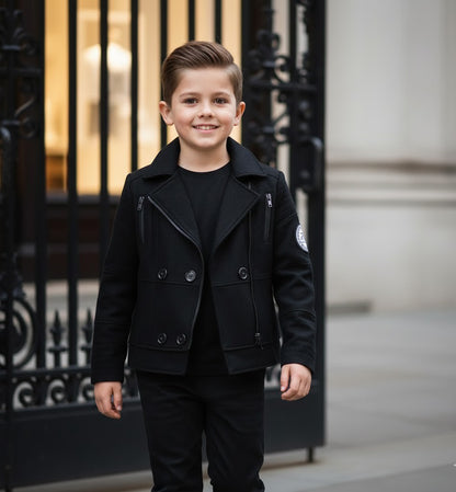 Boys military style jacket in black, modeled by a young boy in an urban setting, showcasing stylish kids outerwear.