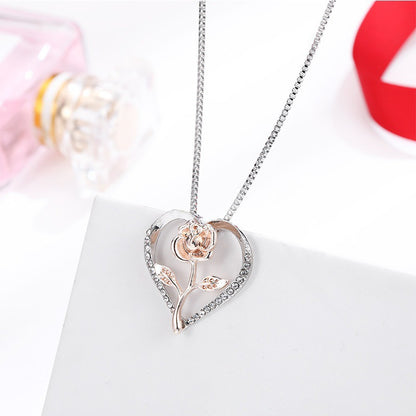 Zircon Heart Rose Silver Necklace for Women elegantly displayed on a white surface with a pink perfume bottle in the background.