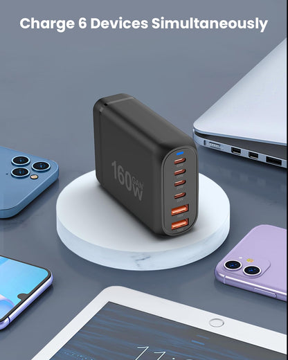 160W USB-C Fast Charger on a table charging multiple devices simultaneously.
