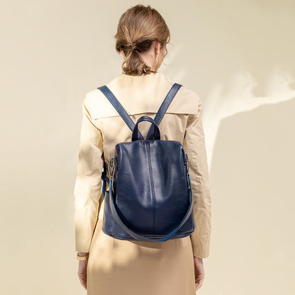 Large-capacity anti-theft leather backpack showcased on a woman wearing a stylish coat from the back.