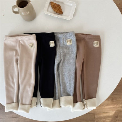 fleece-lined girls leggings in beige, black, gray, and brown displayed on a table.
